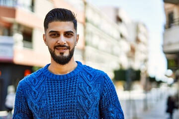 Young arab man smiling confident at street