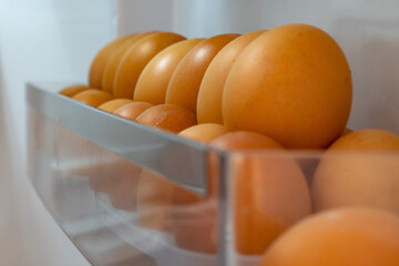 closeup of a pile of brown chicken eggs in the fridge