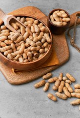 Image of wooden spoons with peanuts on a concrete surface