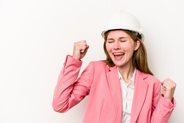Young architect English woman with helmet isolated on white background raising fist after a victory, winner concept.