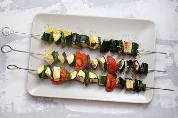fresh grilled vegetables in stick on big gray dish