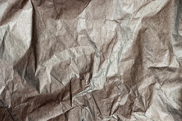 Rumpled dark gray paper texture background close-up