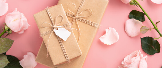 Valentine's Day design concept background with pink rose flower and gift on pink background.
