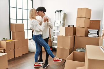 Young beautiful couple smiling happy dancing at new home