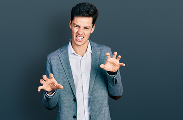 Young hispanic man wearing business clothes smiling funny doing claw gesture as cat, aggressive and...