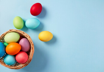 Basket with Colorful Easter Eggs on Blue Background