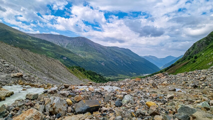 Patara Enguri River flowing down the a valley in the Greater Caucasus Mountain Range in Georgia, Svaneti Region, Ushguli. The source of the river is the Shkhara Glacier. Melting water. Highlands.