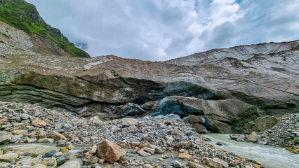 Patara Enguri river flowing out of the Shkhara Glacier in the Greater Caucasus Mountain Range in Georgia, Svaneti Region, Ushguli. Global Warming, Stone terrain. Climate change. Glacier melting.