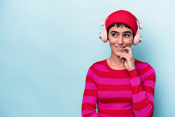 Young caucasian woman listening to music isolated on background relaxed thinking about something looking at a copy space.