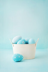 pastel blue easter eggs in basket on blue background