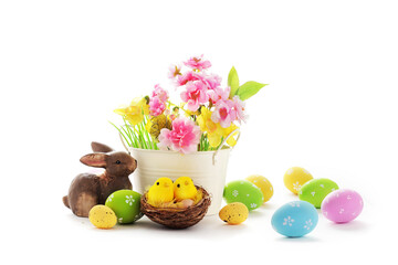 basket with colorful easter eggs and spring flowers isolated on white background