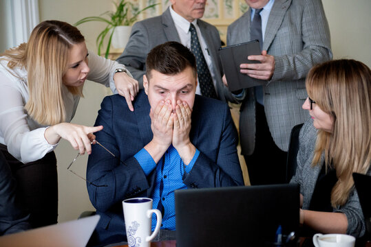 Business man covering his face with his hands, stressful situation in the workplace