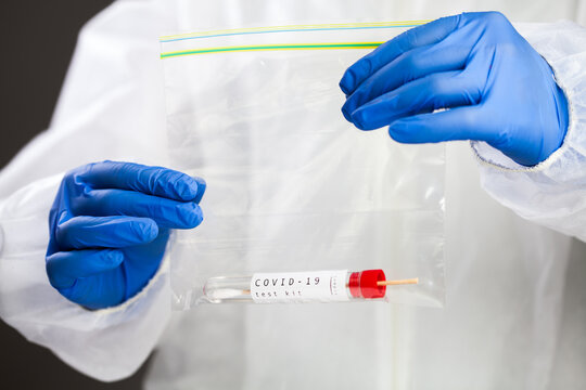 COVID-19 Virus Disease Self Swab Test Sample Kit, Medical Laboratory Scientist Holding A Plastic Bag Containing Test Tube With Throat Or Nose Swab Viral Specimen Collection Equipment, Coronavirus