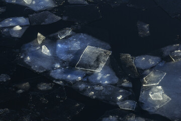 Ice of different shapes in dark water