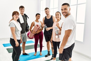 Fototapeta premium Group of young sporty people smiling happy and looking to the camera at sport center.