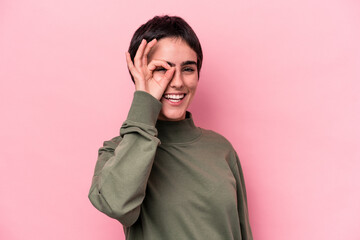 Young caucasian woman isolated on pink background excited keeping ok gesture on eye.