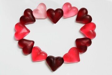 bright, red and pink, jelly hearts in the glare of light on a light background in the shape of heart