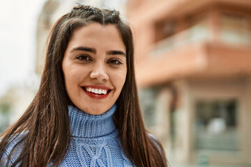 Young hispanic girl smiling happy standing at the city