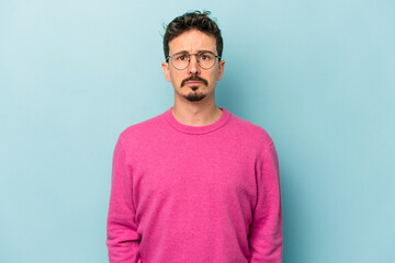 Young caucasian man isolated on blue background sad, serious face, feeling miserable and displeased.