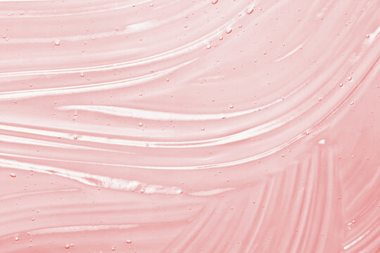 Pink serum gel texture. Clear skincare cream background. Transparent colored cosmetic product close up