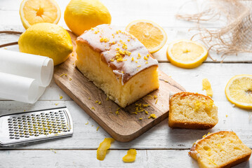 Several slices of lemon cake, lemon sponge cake, homemade, with sugar, flour, honey, yeast and lemons, dessert or for breakfast, on a wooden background.