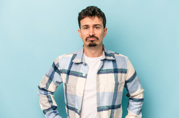 Fototapeta premium Young caucasian man isolated on blue background sad, serious face, feeling miserable and displeased.