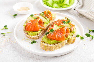 Open sandwiches with salted salmon, guacamole avocado and microgreens. Seafood. Healthy food.