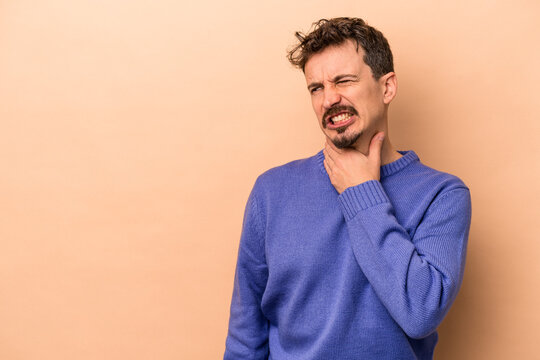Young caucasian man isolated on beige background touching back of head, thinking and making a choice.