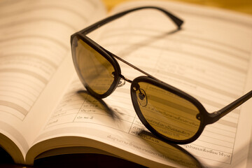 
Glasses and books placed on the table in the living room. educational concepts and knowledge in the evening