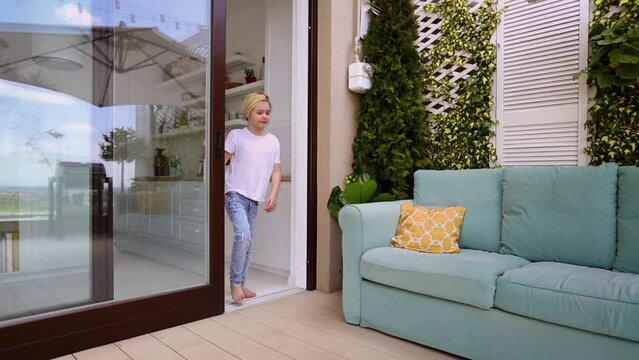 young boy opens sliding door, going to the patio at rooftop apartment