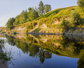 green hill on the bank of the river on a summer day