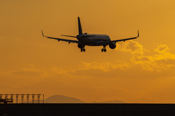 Fototapeta na wymiar 夕焼けの山口宇部空港に着陸するジェット旅客機
