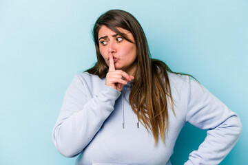 Young caucasian overweight woman isolated on blue background keeping a secret or asking for silence.