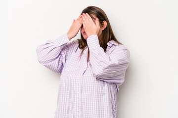 Young caucasian overweight woman isolated on white background afraid covering eyes with hands.