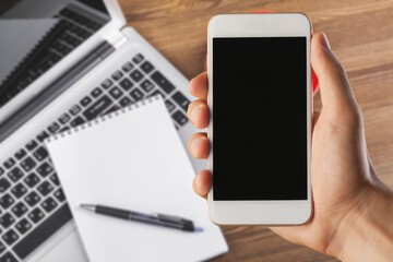 Male hand holding a smartphone with a blank screen