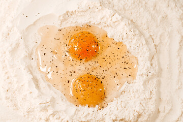 Cooking homemade dough, flour and eggs on the table. Pepper on eggs. Cooking at home, recipes, diet