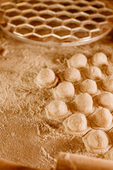 Making homemade dumpling dough. The rolling pin rolls out dough, flour and a mold for dumplings or ravioli. Home cooking food. National cuisine