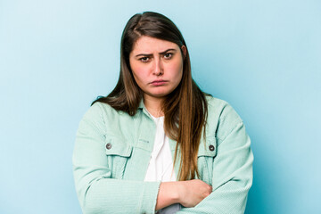 Young caucasian overweight woman isolated on blue background unhappy looking in camera with sarcastic expression.