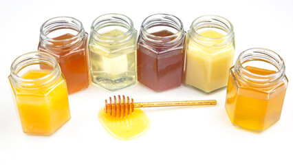 spoon with fresh honey and jars with different types of honey on a white background. organic vitamin food