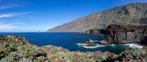 El Hierro - Bewachsene vulkanische Felsenküste im El Golfo Tal nahe Las Puntas mit Blick zu den...