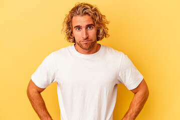Young caucasian man isolated on yellow background sad, serious face, feeling miserable and...