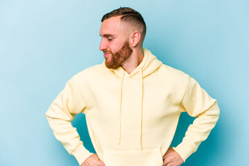 Fototapeta premium Young caucasian man isolated on blue background dreaming of achieving goals and purposes