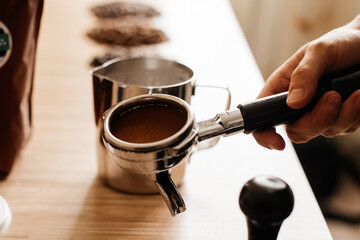 Barista cooks coffee, holds a horn in his hand