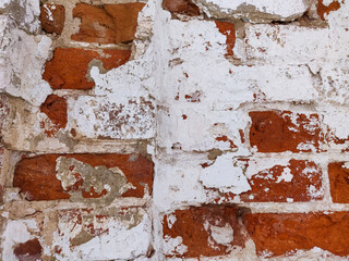 a wall of old bricks with fallen plaster for the background