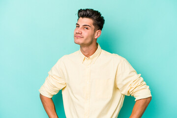 Young caucasian man isolated on blue background dreaming of achieving goals and purposes