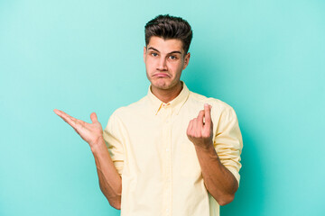 Young caucasian man isolated on blue background showing that she has no money.