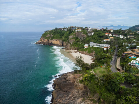 Aerial view of Praia da Joatinga, a paradise in Rio de Janeiro, Brazil. Sunny day with some clouds in the morning. Sea with good waves for surfers. Drone photo