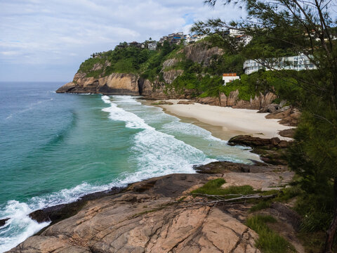 Aerial view of Praia da Joatinga, a paradise in Rio de Janeiro, Brazil. Sunny day with some clouds in the morning. Sea with good waves for surfers. Drone photo