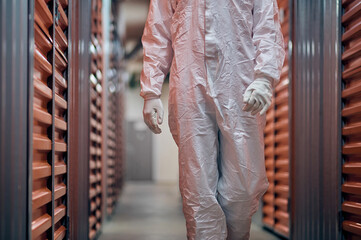 Worker in a hazmat suit inspecting in the storage equipment