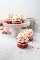 Red velvet cupcake with cream cheese frosting and red hearts sprinkles on the top. Valentine's Day concept. Selective focus.